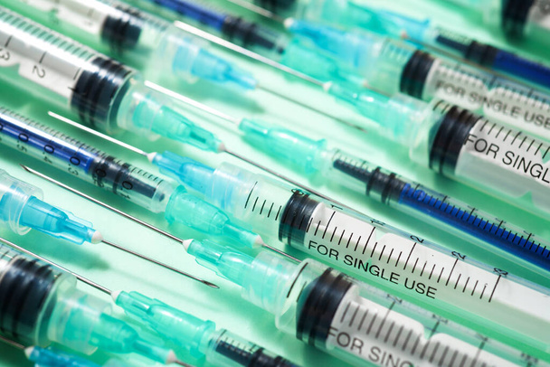 Close up of a group of syringes on a green table. - Photo, Image