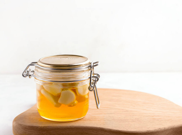 Fermentierter Honig mit Knoblauch auf einem weißen Teller. Kopierraum - Foto, Bild
