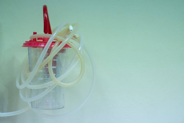 zuig-unit buis en opslagtank voor slijm van patiënt en zuurstof stroomregelaar met buisschaal voor hulp bij het ademhalen van patiënten aan de wand in het ziekenhuis - Foto, afbeelding
