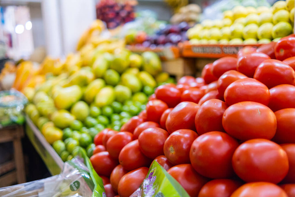 Värikäs vihannesten ja hedelmien seistä tomaatit, viinirypäleet, mangot, ja enemmän - Valokuva, kuva