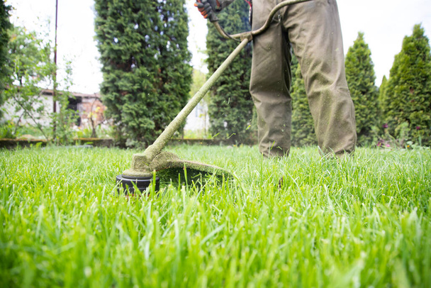 Mowing the grass with a lawn mower. Garden work concept background. - Fotó, kép