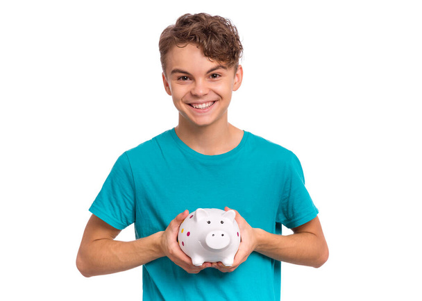 Teen boy holding piggy bank - Fotó, kép