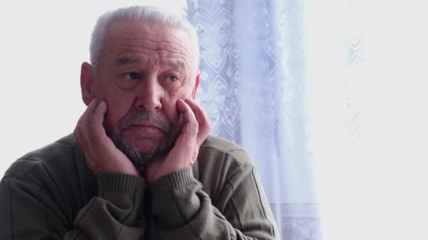 An elderly gray-haired man has a headache.  - Záběry, video