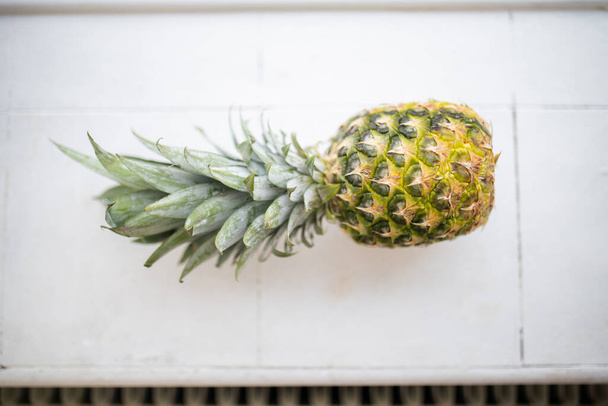 Fresh pineapple on a white tiled kitchen counter - Photo, Image