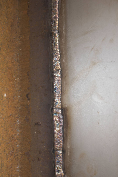 een lasnaad op een metalen voorwerp na het lassen - Foto, afbeelding