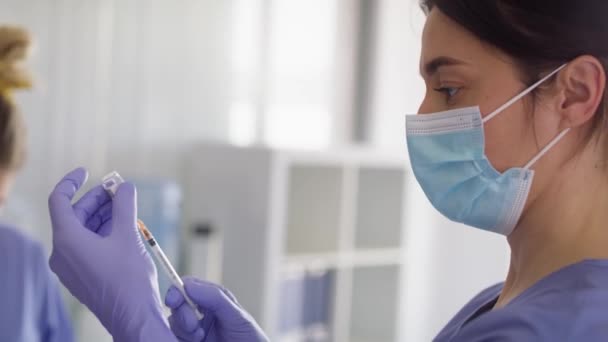 Video van vrouwelijke arts die de vrouw klaarmaakt voor vaccinatie. Opgenomen met RED helium camera in 8K. - Video