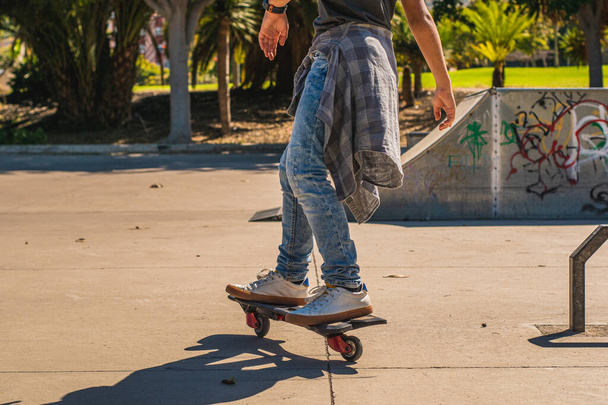 Ragazzo irriconoscibile che pattina con il suo skateboard in uno skate park - Foto, immagini