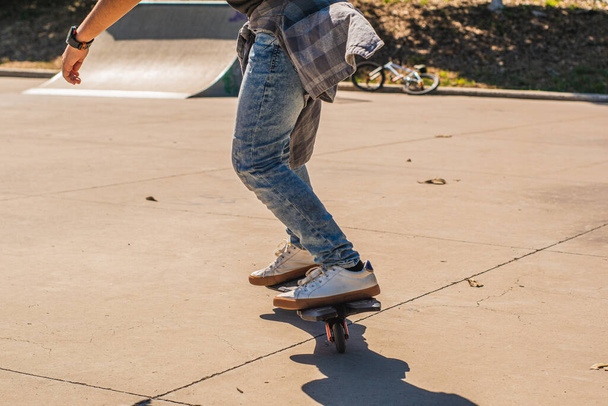 Rapaz irreconhecível patinando com seu skate em um parque de skate - Foto, Imagem