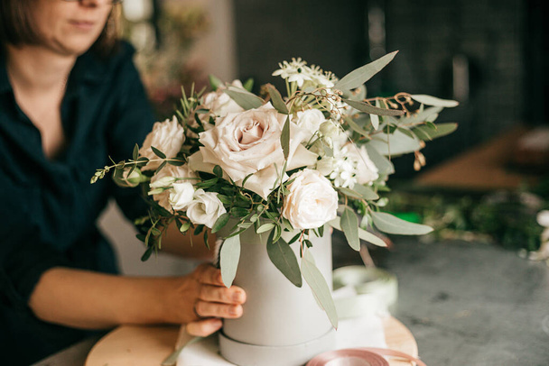 Pracovní prostředí v květinářství, Květinářství vytváří kytice z čerstvých bílých růží. Koníček hobby nebo malé podnikání - Fotografie, Obrázek