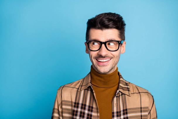 Portrait of young handsome dreamy cheerful positive smiling man in glasses look copyspace isolated on blue color background - Фото, зображення
