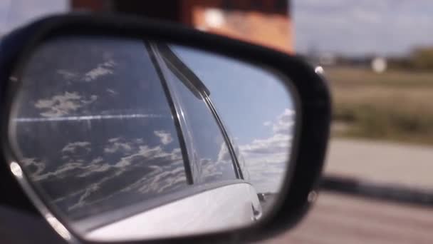 close up της κινούμενης προβολής στο αυτοκίνητο πίσω όψη πλευρά καθρέφτη των νεφών και το πεδίο. Ταξιδεύοντας με αυτοκίνητο έννοια. - Πλάνα, βίντεο