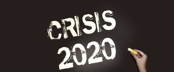 Krize 2020 text na tabuli s křídou. Hospodářská a finanční krize přichází v důsledku převládajícího koronaviru po celém světě. - Fotografie, Obrázek