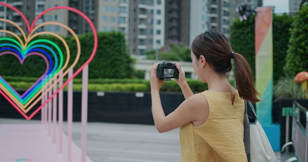 Женщина использует цифровую камеру, чтобы фотографировать на открытом воздухе - Фото, изображение