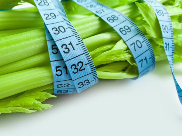 fresh celery measuring tape on white background - Foto, afbeelding