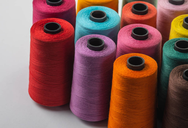 Mix of spools of colored thread on a white background - Foto, imagen