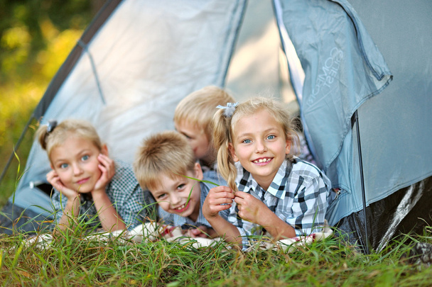 Portrait of young children on a camping holiday - 写真・画像