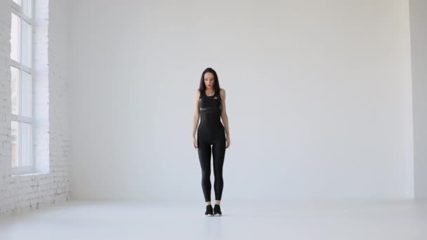 Sport tutorial oefeningen voor beginners. Het volledige uitzicht van de vrouw in zwarte sportschool pak opwarmen door het rollen van de schouders in de studio. - Video
