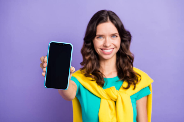Photo of blurred cute wavy young woman dressed pullover shoulders showing modern gadget isolated purple color background - Photo, Image