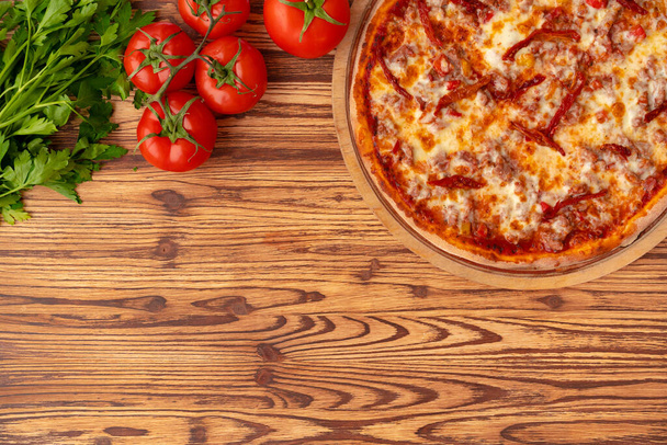 Top view of freshly baked pizza on wooden background - Foto, immagini