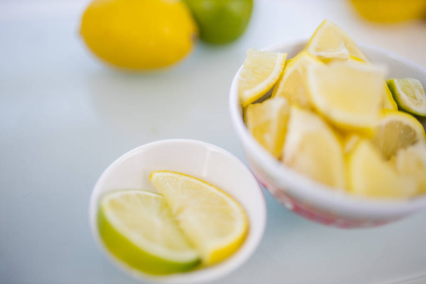 Cuencos de rodajas de limón y frutas en una mesa - Foto, imagen