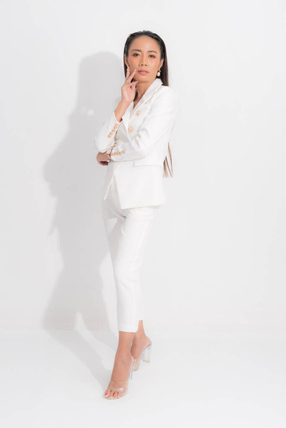 Mode-Stil Katalog Kleidung für Geschäftsfrau schwarz lange Haare natürliches Make-up tragen weißen Anzug Kostüm perfekte Körperform Anzug bei Studio-Shooting auf weißem Hintergrund und Schatten. - Foto, Bild