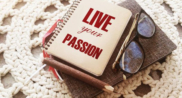 Live your passion on a notebook with glasses and pen. Bsuiness career motivation concept. - Photo, Image