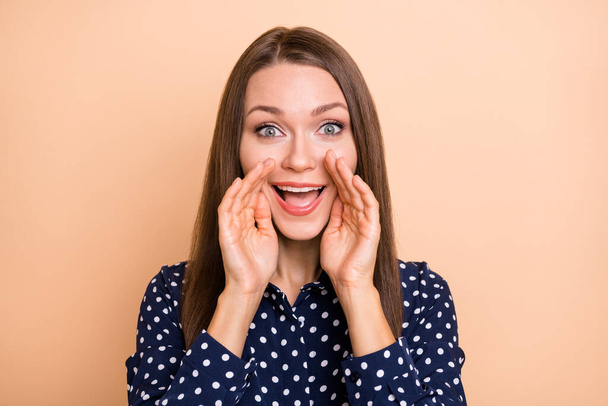 Photo of cute adorable girl dressed dotted blouse arms mouth making announcement isolated beige color background - 写真・画像
