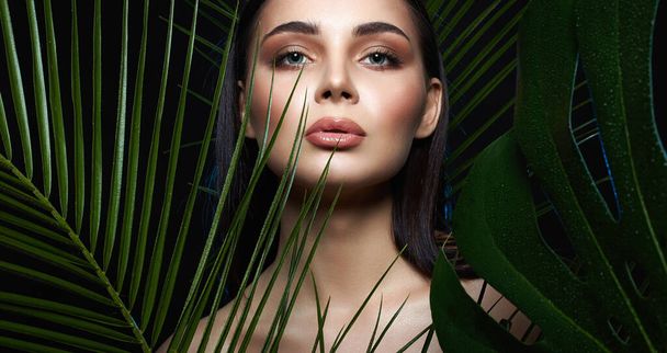 young woman in Jungle. beautiful girl in palms. Beautiful tanned woman with Make-up. Beauty Portrait - Photo, Image