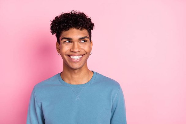 Photo of optimistic nice brunet guy look empty space wear blue sweater isolated on pastel pink color background - Valokuva, kuva