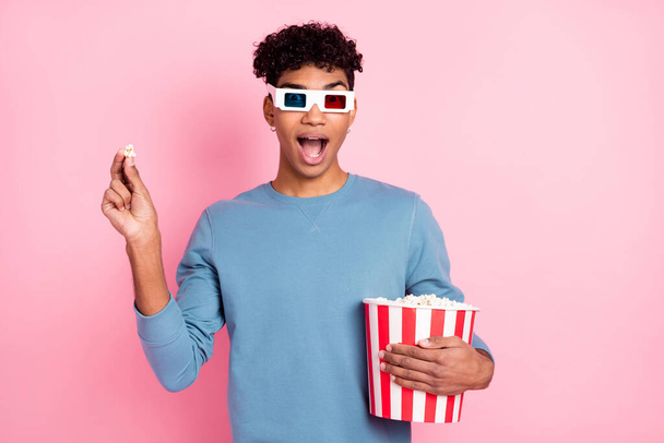 Photo of young black man amazed shocked surprised eat popcorn watch film 3d glasses isolated over pastel color background - Photo, Image