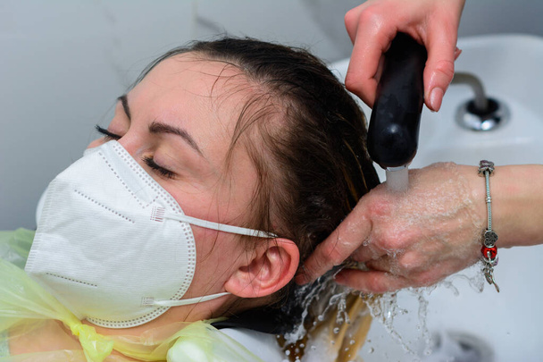 Kobieta w salonie fryzjerskim farbuje włosy, myjąc głowę w procesie farbowania włosów. nowe - Zdjęcie, obraz