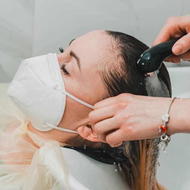 Şampuan üstüne saç yıkama, berber dükkanında saç bakımı karantina sırasında kuaförü ziyaret etme. yeni - Fotoğraf, Görsel