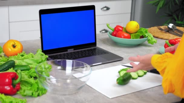 Μπλε οθόνη laptop: Γυναίκα νοικοκυρά στην κουζίνα στο σπίτι χαιρετά λέει δάσκαλος σεφ - Πλάνα, βίντεο
