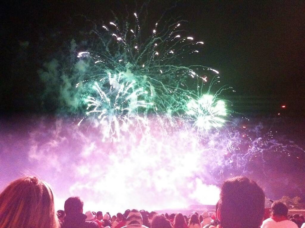 Mensen die vuurwerk kijken op een zomeravond op het San Fermin Festival, Pamplona, Spanje. - Foto, afbeelding