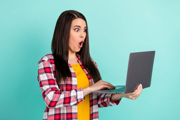 Photo of amazed shocked young woman hold look laptop unexpected news isolated on teal color background - Foto, immagini