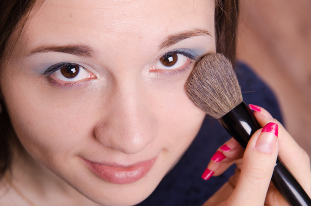 Makeup artist applies powder on face of beautiful girl - Фото, зображення