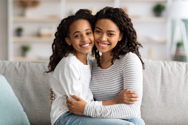 Vrolijk Afrikaans Amerikaans moeder en dochter poseren thuis - Foto, afbeelding