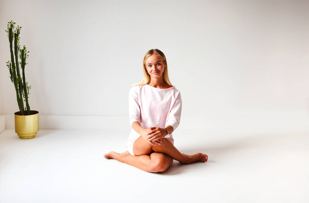 Young blond female in pink sportswear is ready for doing yoga while practicing mindfulness - Foto, Imagem
