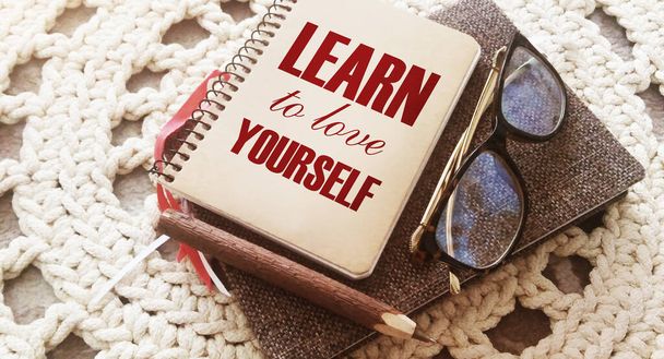 Learn to love yourself words on a notebook with glasses and pen. Bsuiness career motivation concept. - Photo, Image