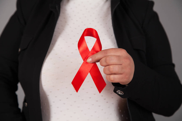 Frauenhände mit rotem AIDS-Bewusstseinsband. - Foto, Bild