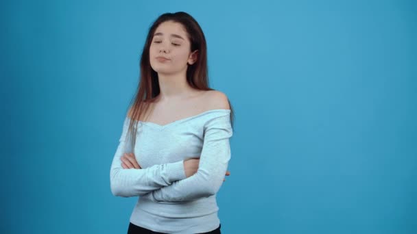 The disappointed girl crosses her hands with a pipette, moves her gaze down and puts her lip upside down. Asian with dark hair, dressed in a blue blouse, isolated on a dark blue background in the - Video, Çekim