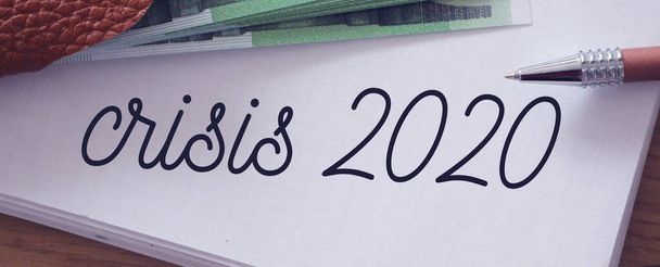 Kriz 2020, sayfa dolusu defter ve 100 Euro 'luk banknotlar halinde yazılmış. Az para kaldı, iş iflas konsepti.. - Fotoğraf, Görsel