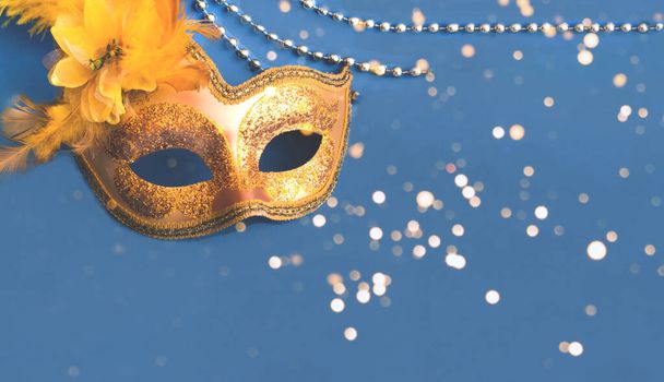Carnival golden mask on blue background with silver beads. Mardi Gras concept. Copy space - Foto, afbeelding