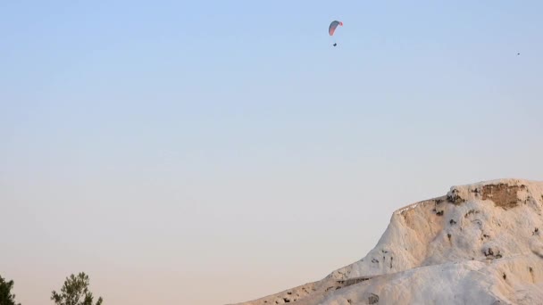 Hang sikló siklóernyő travertin Pamukkale, turisztikai természeti világörökség részére.Hang siklóernyő felett felfüggesztett repüléstechnika emelkedő reggeli magaslati termikus felfújt léghajó repülni aerosztát szabadság közlekedési tevékenység extrém emberek kalcium 4K - Felvétel, videó