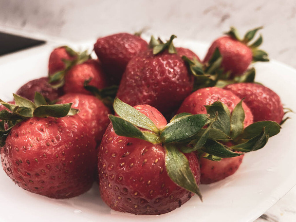 Saftige und schmackhafte reife Erdbeeren auf einem Esstisch. Schöne und schmackhafte süße Beeren. - Foto, Bild