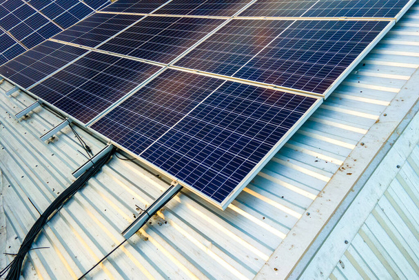 Vista aérea da superfície dos painéis solares fotovoltaicos azuis montados no telhado da construção para produzir eletricidade ecológica limpa. Conceito de produção de energias renováveis. - Foto, Imagem