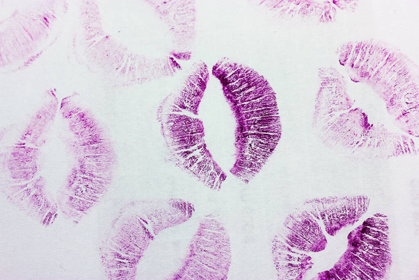 Besos púrpura abstractos aislados sobre fondo blanco. Un montón de huellas de labios femeninos en papel. Hermosos labios sellos aislados. Día de San Valentín, ambiente romántico y concepto de amor. Besos de lápiz labial. Impresión de labios - Foto, Imagen
