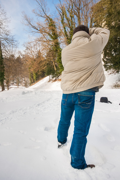 bevétel mozi-ból egy hóval borított lazán öltözött fotós  - Fotó, kép