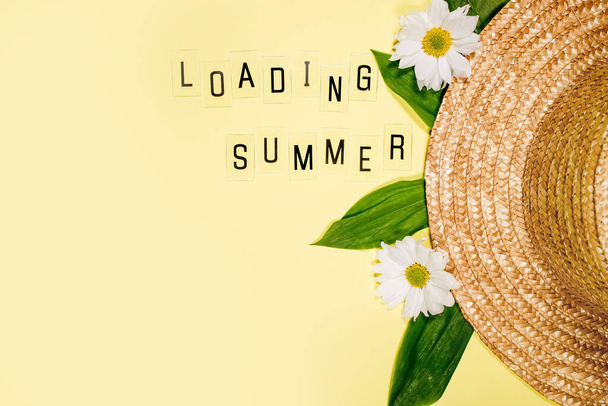 Női nyári szalma kalap sárga háttér felső nézet lapos laikus másolási hely. Nyári nyaralás koncepció, egyetlen dolog. Szöveg ÖSSZEFOGLALÁS betűk és mező kamilla virágok sárga. - Fotó, kép
