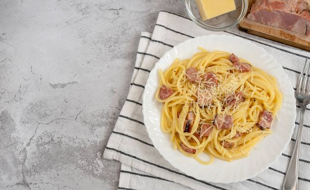 Спагетті карбонара з млинцетом і пекоріно романо сиром на білій тарілці
 - Фото, зображення